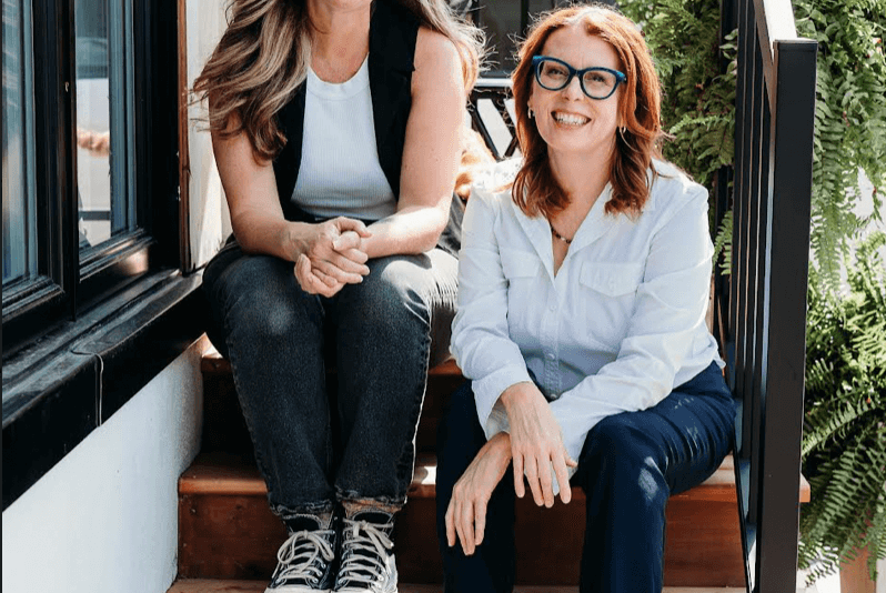 Owners of M&N Apothecary smiling and standing together at their local store, expressing gratitude to customers for their support during the holiday season.