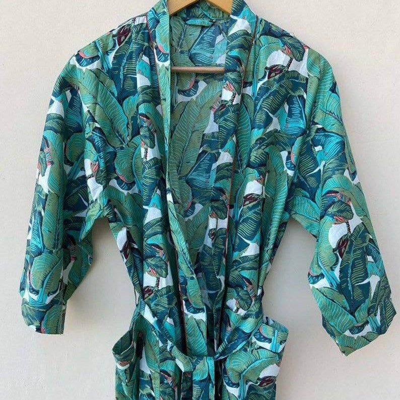 Bohemian pure cotton banana leaf kimono bath robe hanging on a wooden hanger with vibrant leaf print.