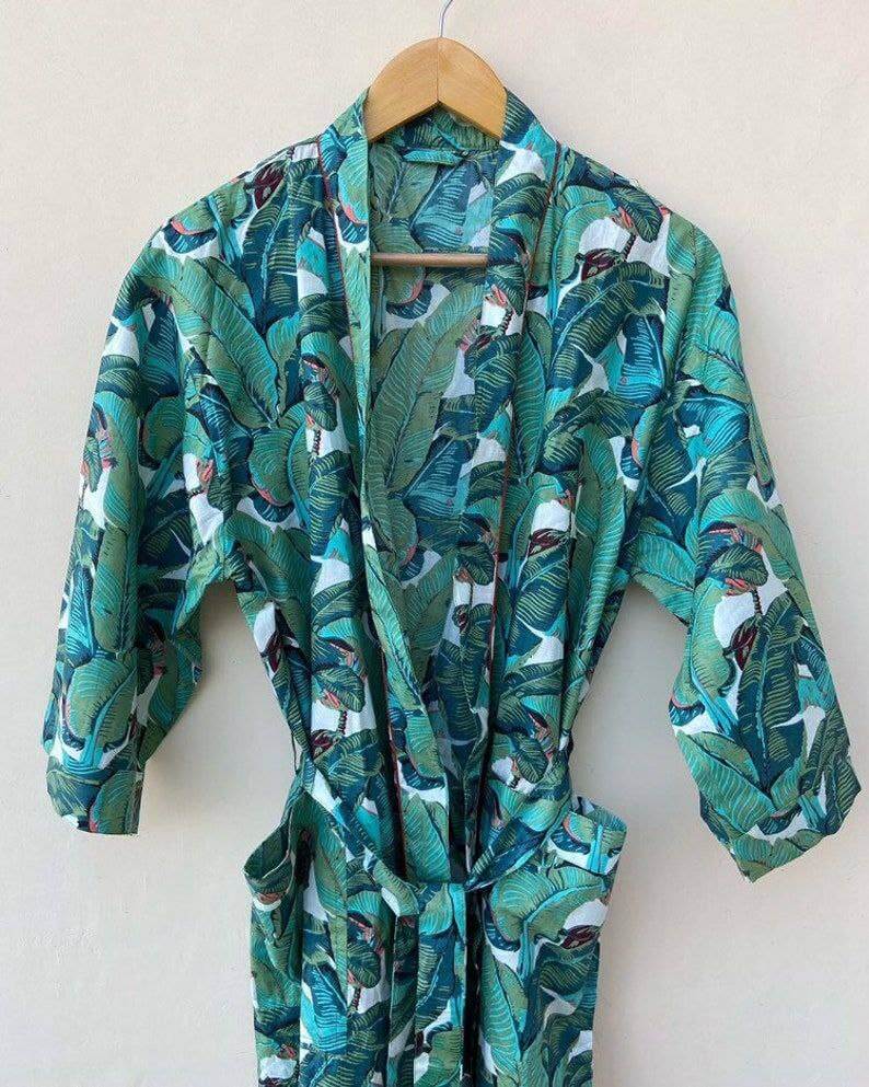 Bohemian pure cotton banana leaf kimono bath robe hanging on a wooden hanger with vibrant leaf print.