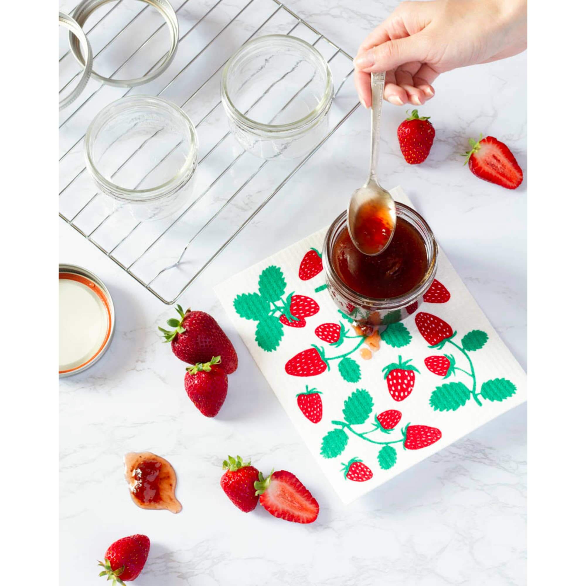 Swedish dishcloth featuring strawberries used for wiping spills while preparing jam.
