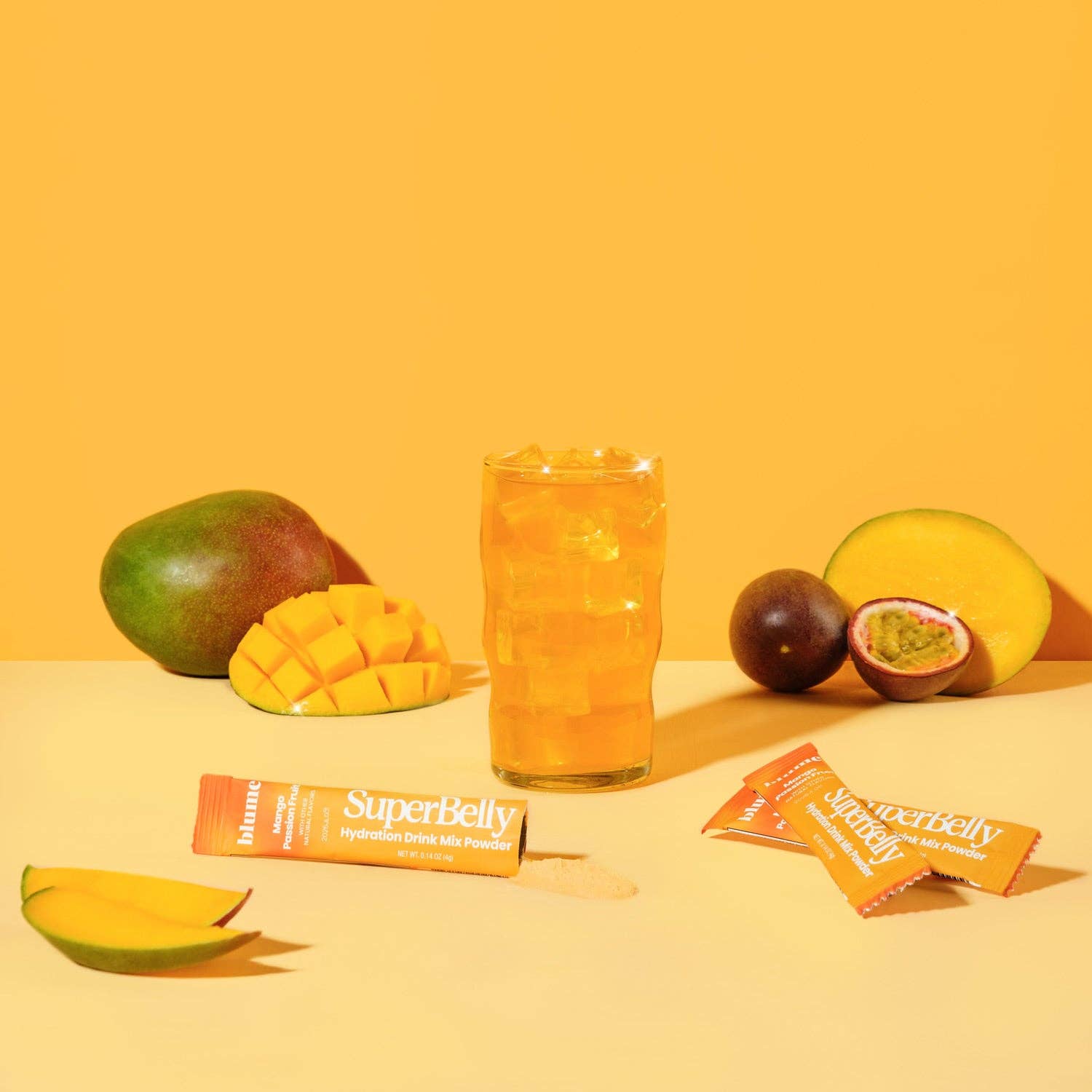 SuperBelly hydration drink powder in mango passionfruit flavor with fresh fruits and a refreshing glass of drink.