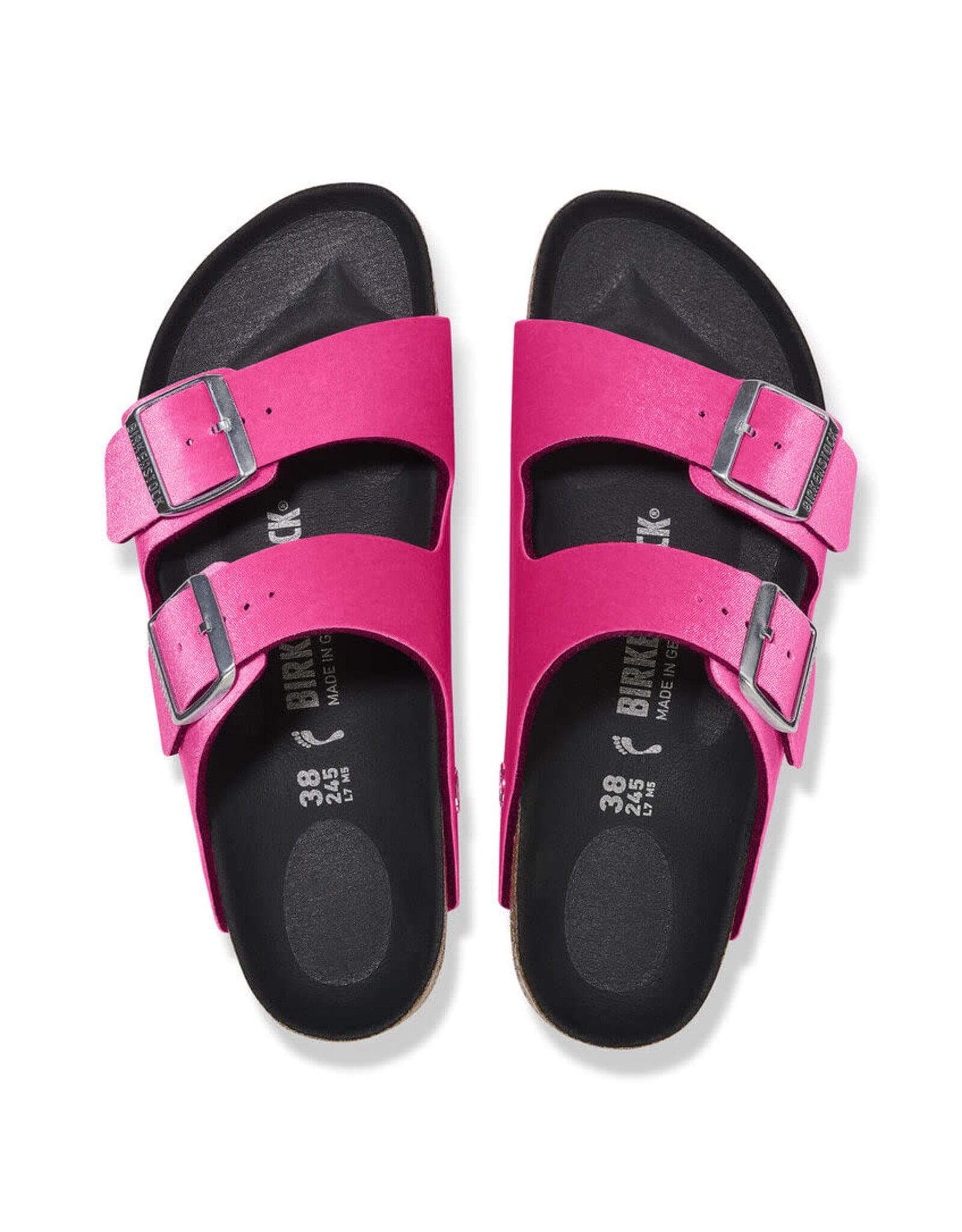 Birkenstock Women's Arizona Sandals in bright pink with rivet buckles and smooth black footbed, top view.