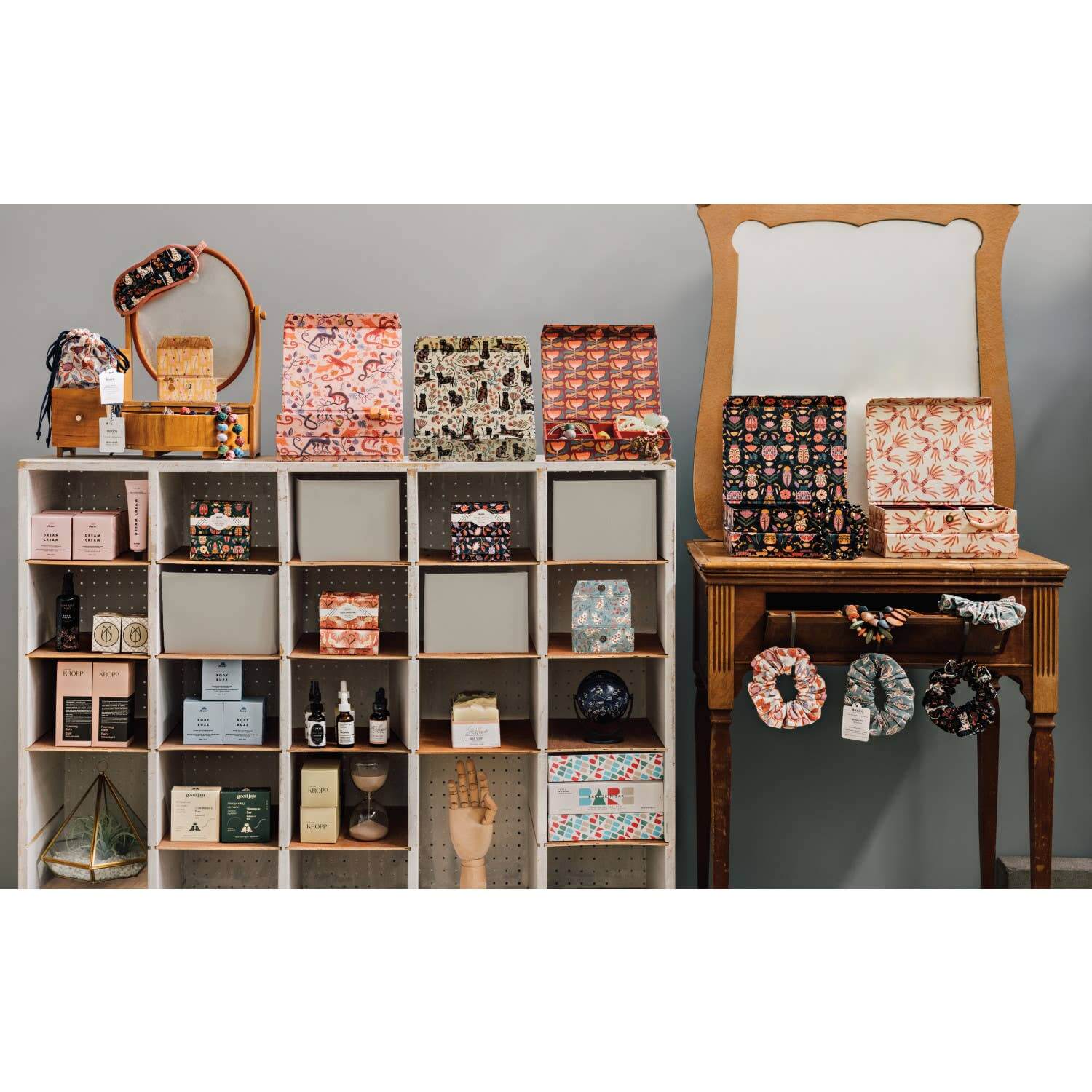 Display of Catbloom sleep masks and gift boxes on shelves and a vintage table with a mirror.
