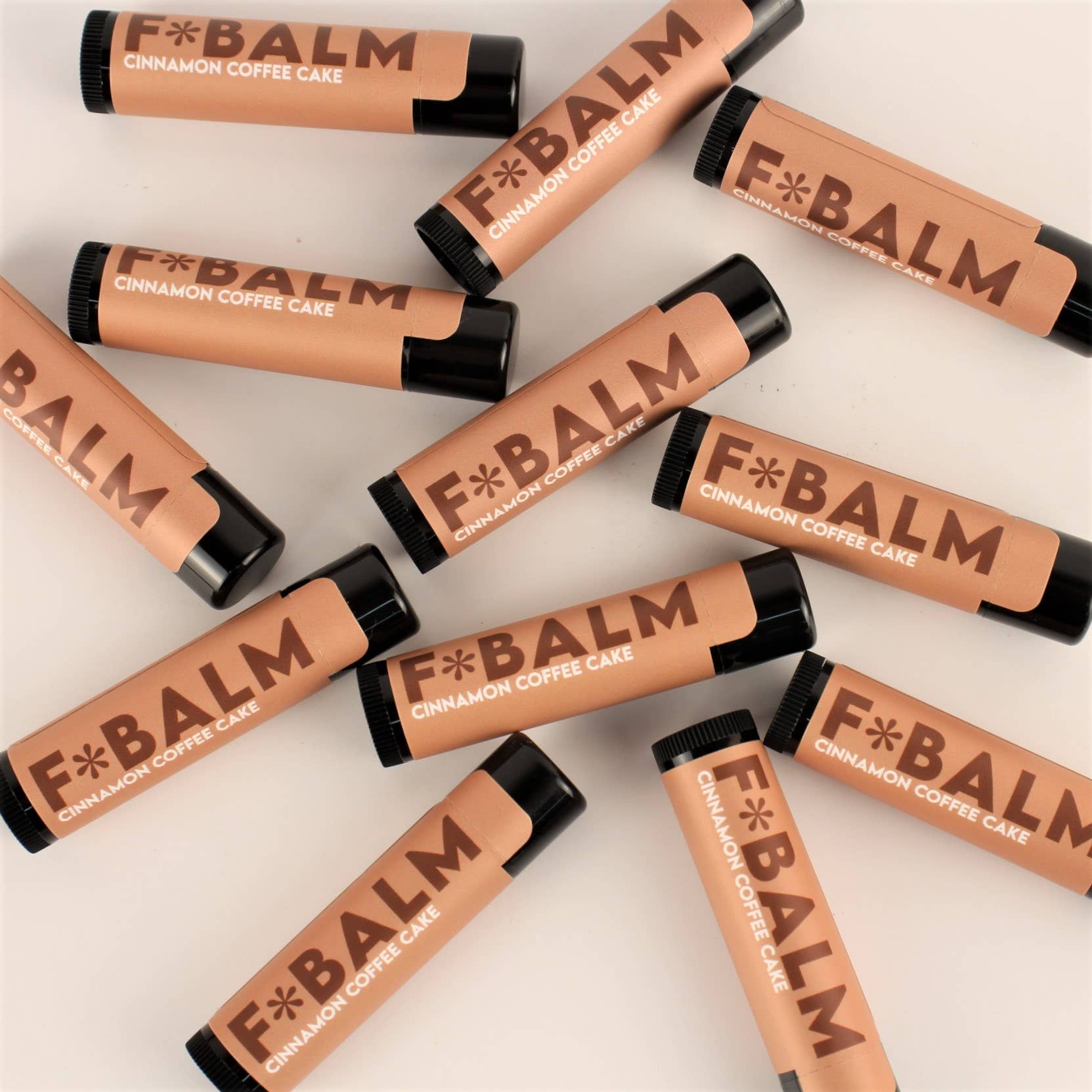 F*BALM Cinnamon Coffee Cake lip balms arranged flat, showcasing all-natural ingredients for smooth, moisturized lips.
