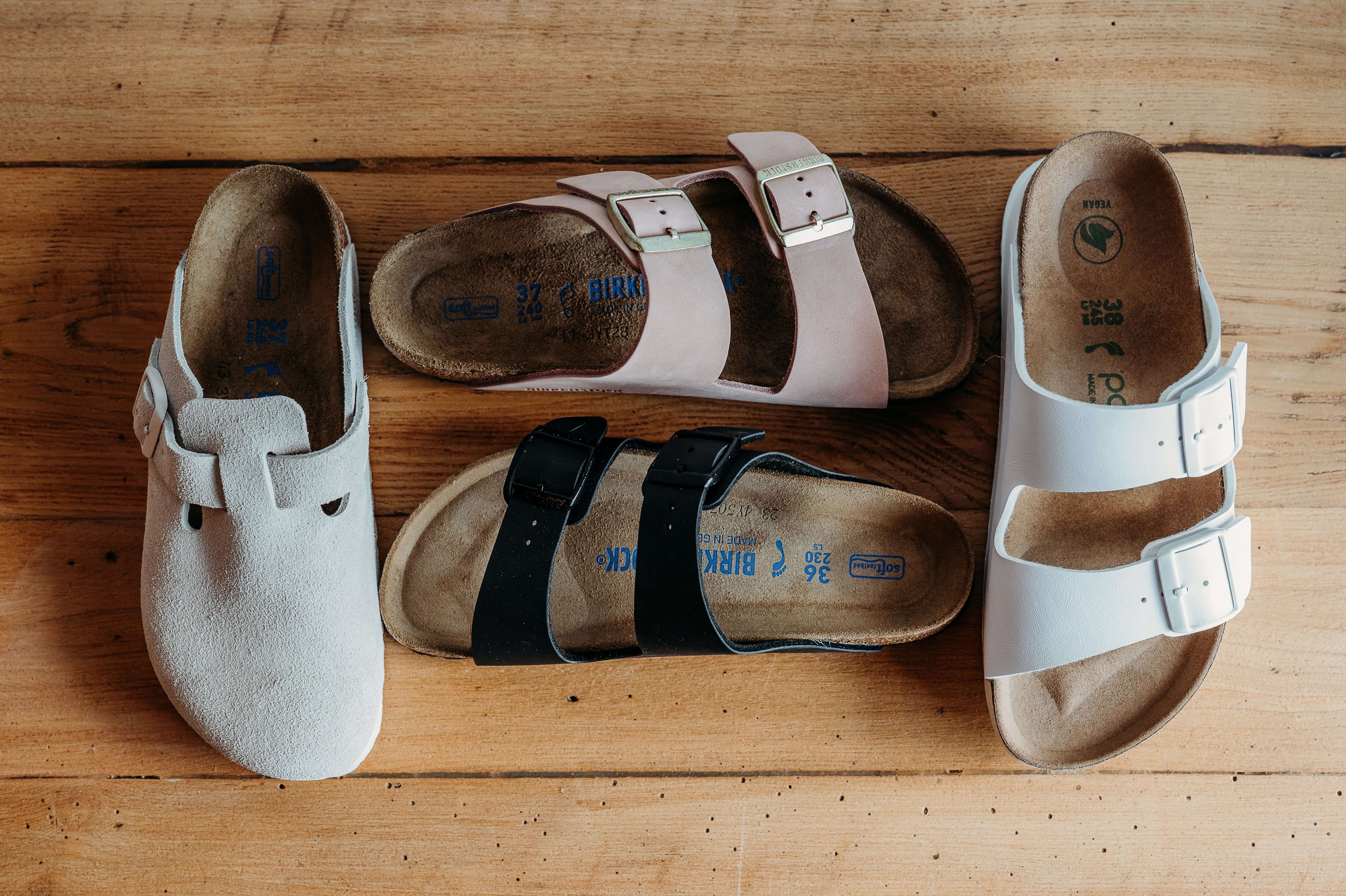 Four style of Birkenstock spead out across the fllor in pink, white, taupe and black