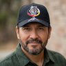 Man wearing a black cap with a wolf design outdoors