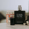 Dark Rose eau de parfum bottle on a surface with decorative items in the background