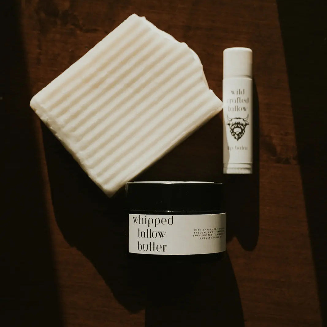 Three skincare products on a wooden surface: a jar, a bottle, and a soap bar.