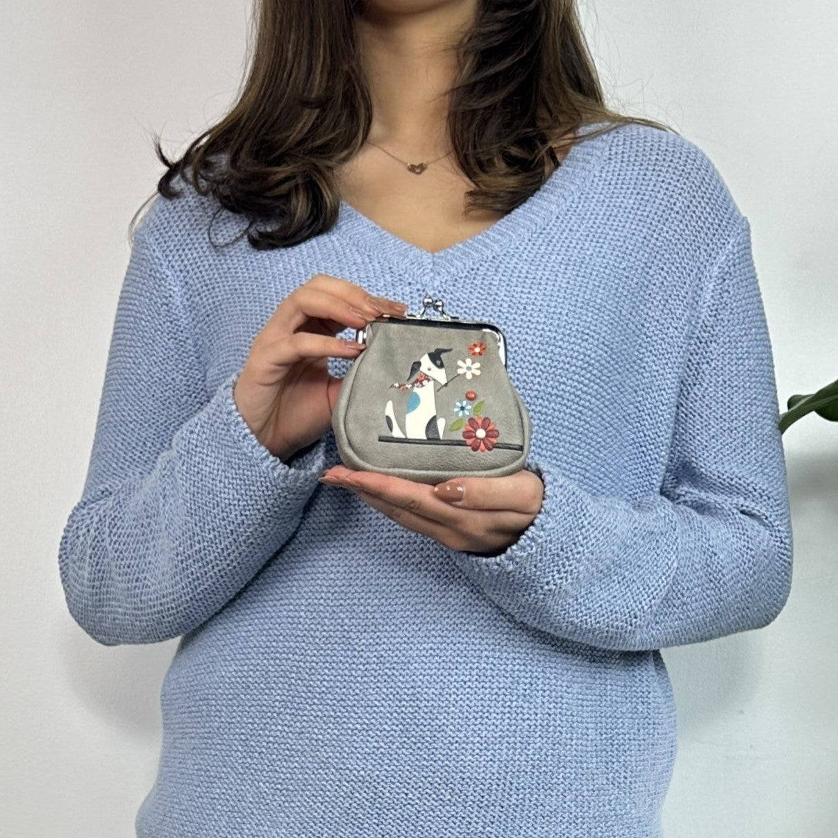 A small grey Espe Vegan Corp coin purse with a silver kiss-lock clasp, 