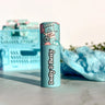 Lip balm with 'Dolly & Betty' branding on a marble surface with cotton candy-themed packaging.