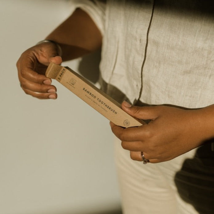 Person holding a wooden spatula with a blurred background