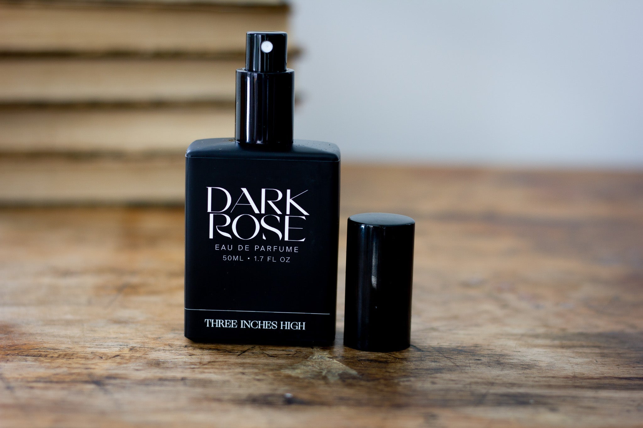 Black 'Dark Rose' perfume bottle on a wooden surface