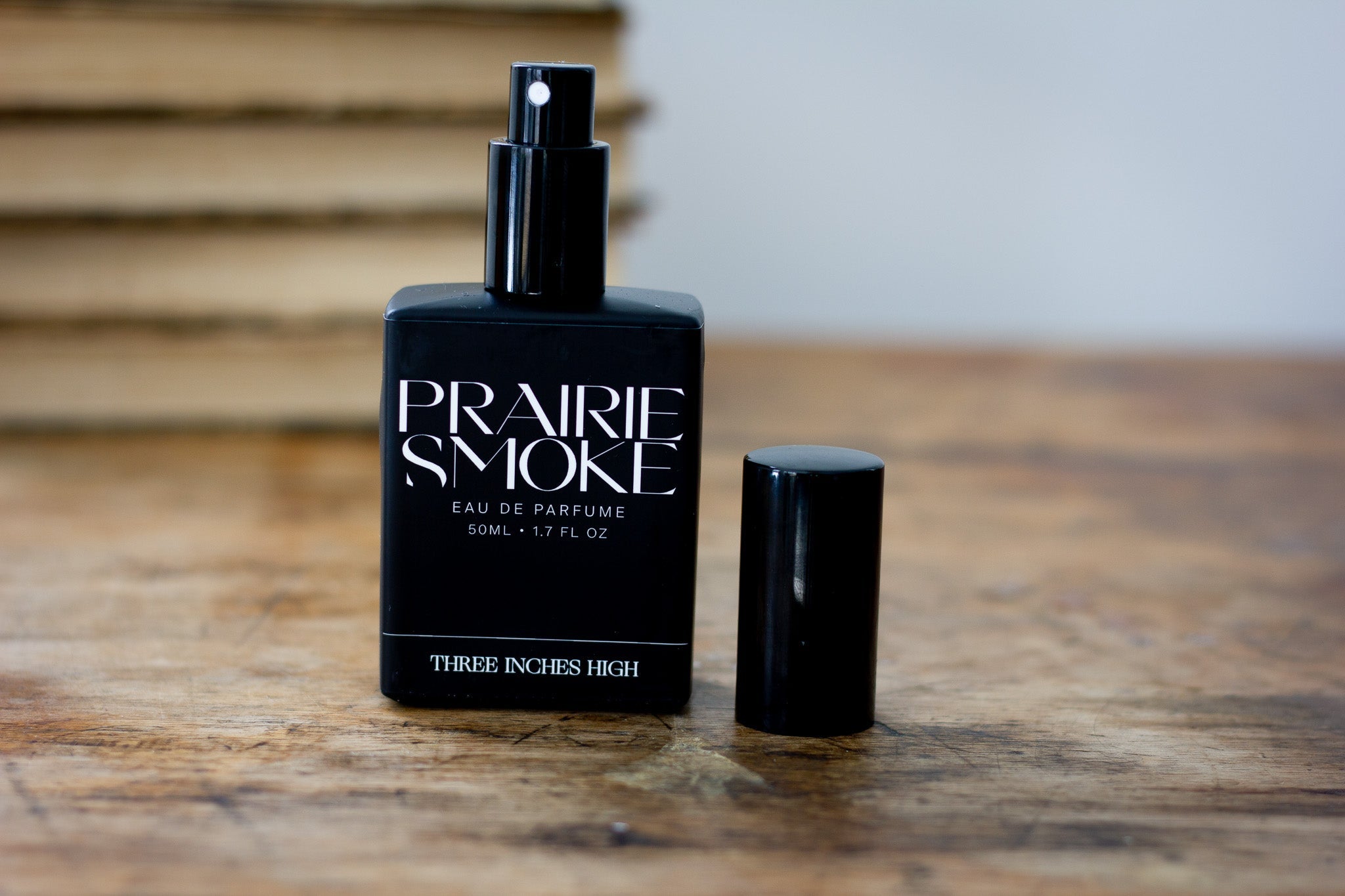 Black 'Prairie Smoke' perfume bottle on a wooden surface