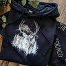 Still North Design Co Navy blue hoodie with deer design on a wooden surface
