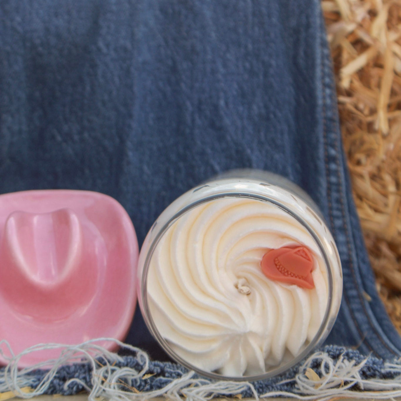 Two small round containers with lid designs on a denim fabric background