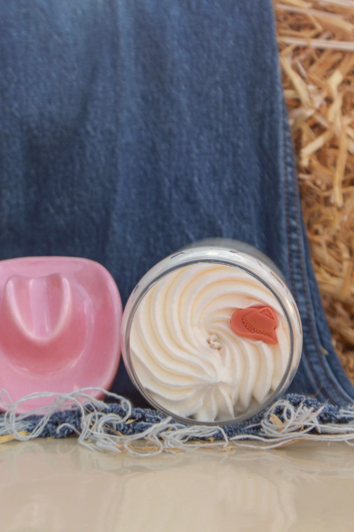 Two small round containers with lid designs on a denim fabric background
