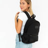 Woman wearing a black backpack on a white background