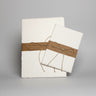 Two packs of handmade watercolor paper with brown ribbons on a white background