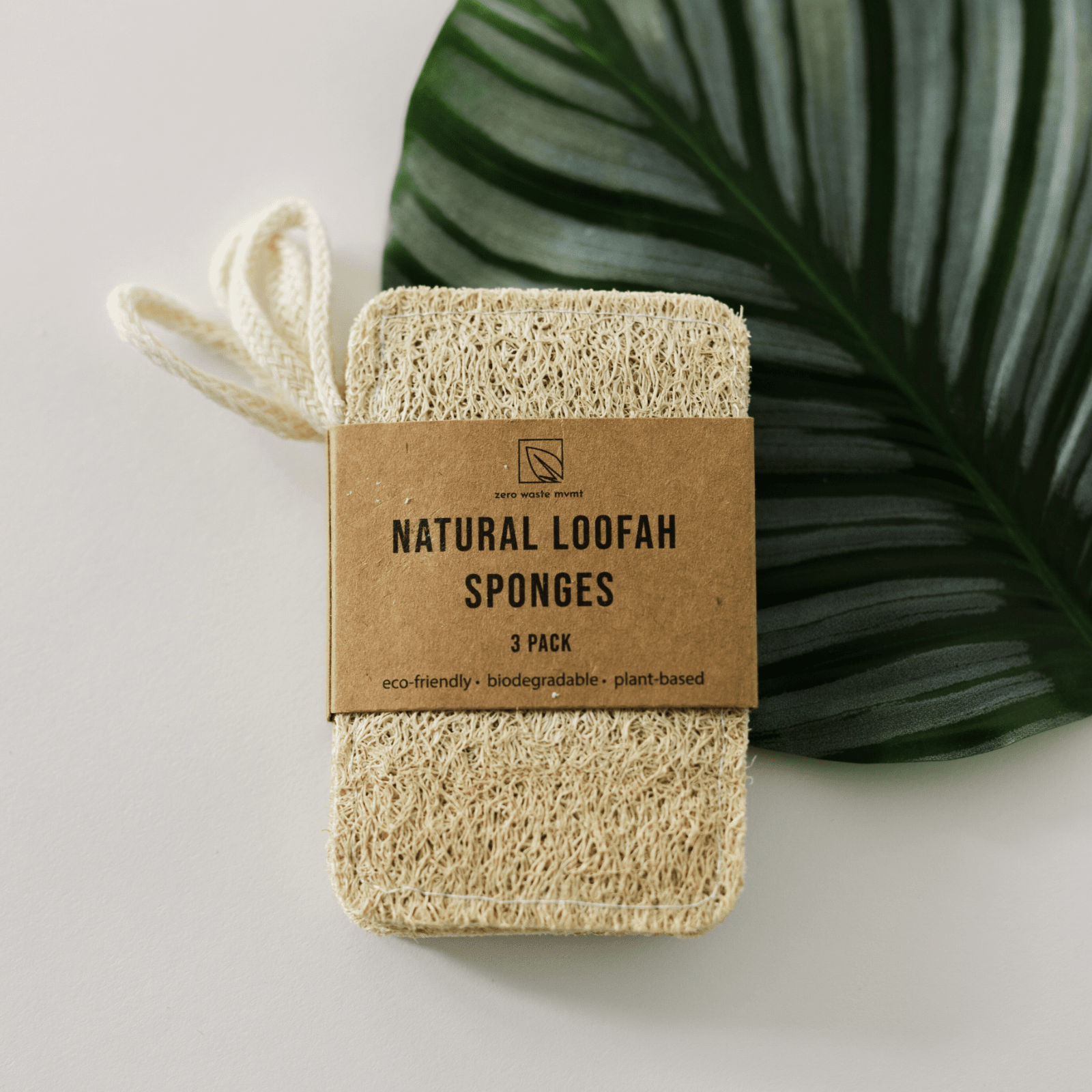Three natural loofah sponges with a brown label on a light background