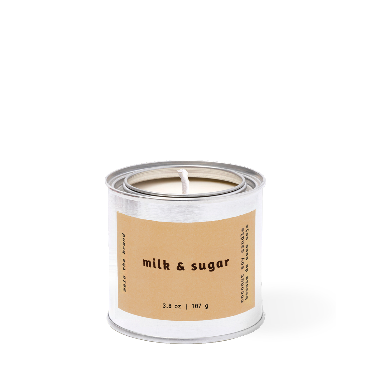 Candle in a metal container with 'milk & sugar' label on a white background