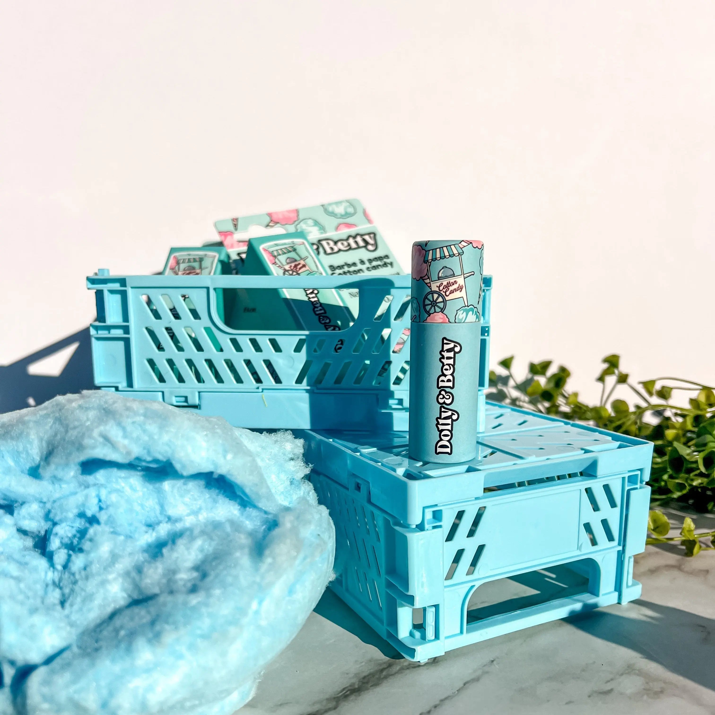 Blue crates with 'Dolly & Betty' products on a light background