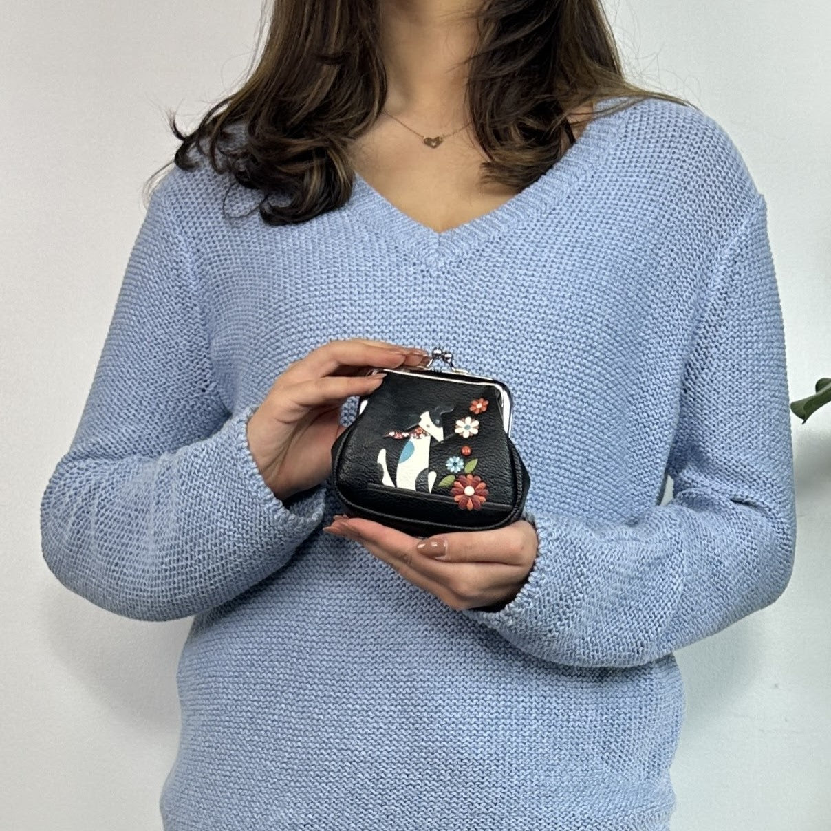 A small black Espe Vegan Corp coin purse with a silver kiss-lock clasp, 
