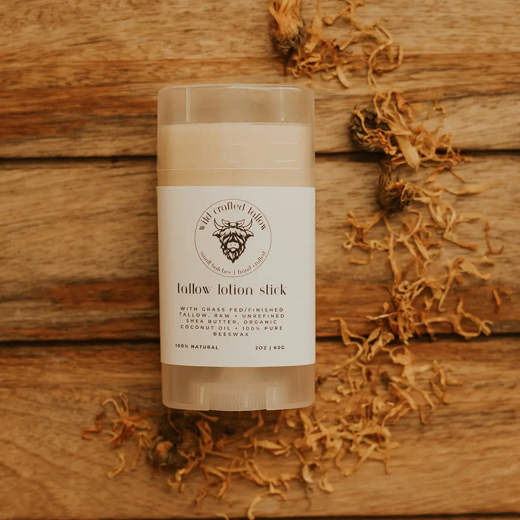 Tallow lotion stick on a wooden surface with a label