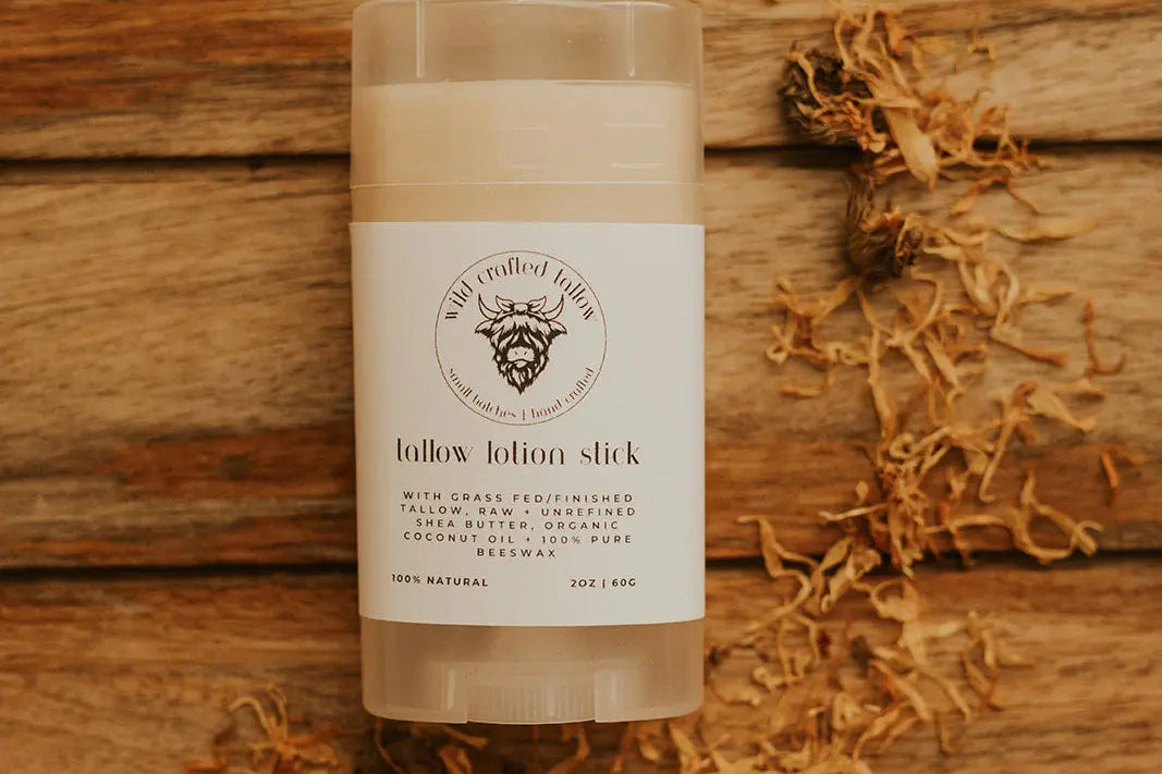 Tallow lotion stick on a wooden surface with a label