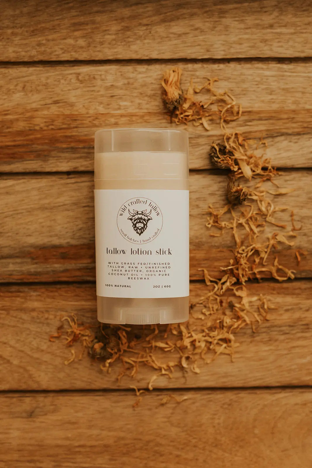 Tallow lotion stick on a wooden surface with a label