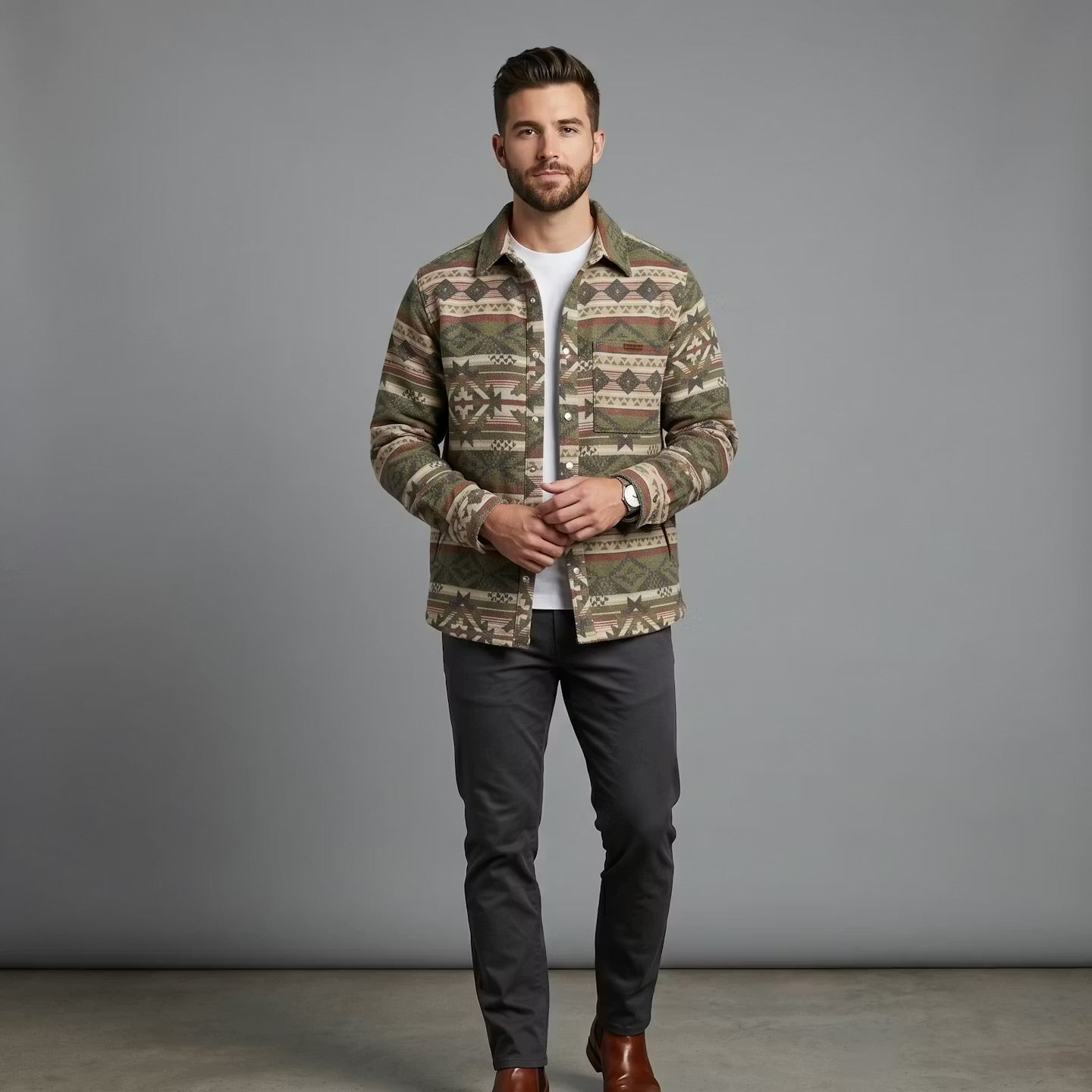 OldTribes Man wearing a patterned jacket over a white shirt with dark pants on a grey background
