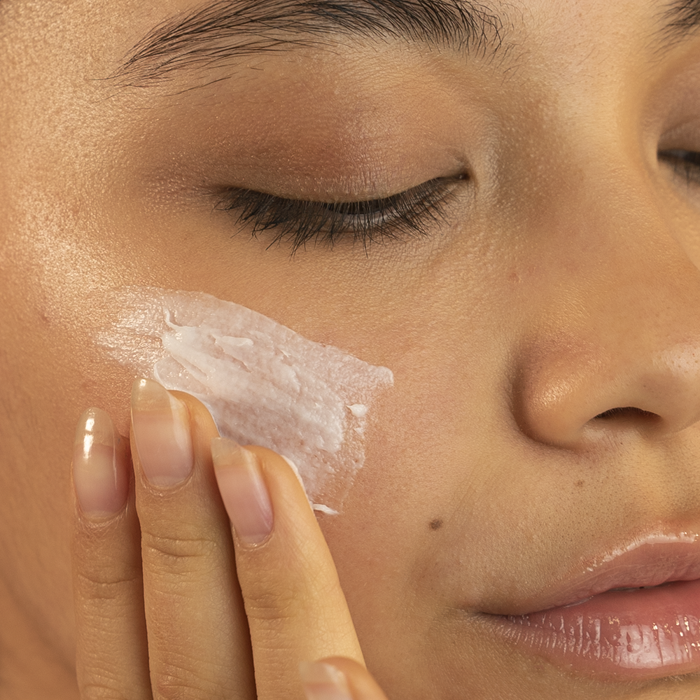 Close-up of a person applying cream to their face