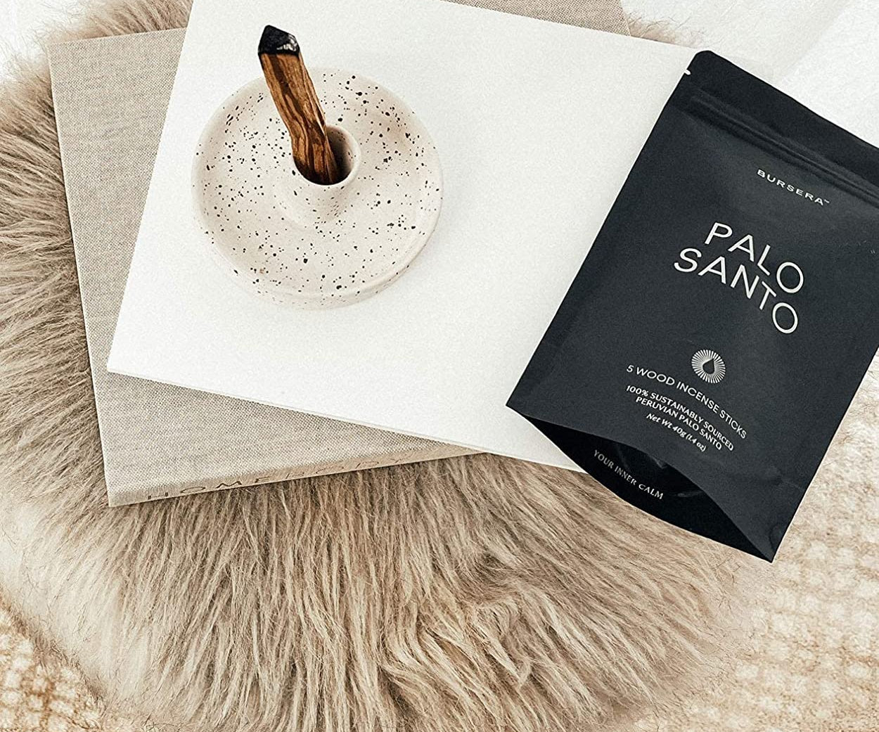 Palo Santo incense sticks in a black packaging on a textured surface