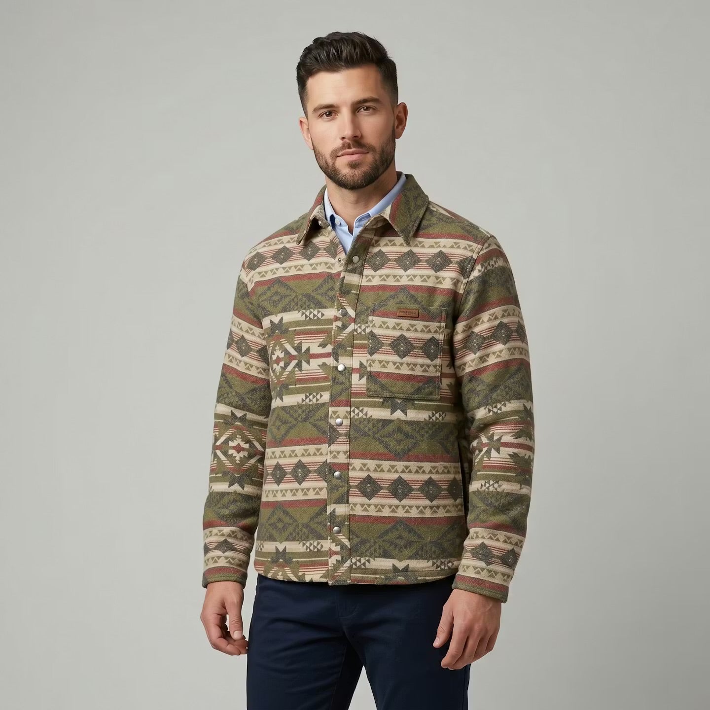 OldTribes Man wearing a patterned shirt over a collared shirt on a gray background