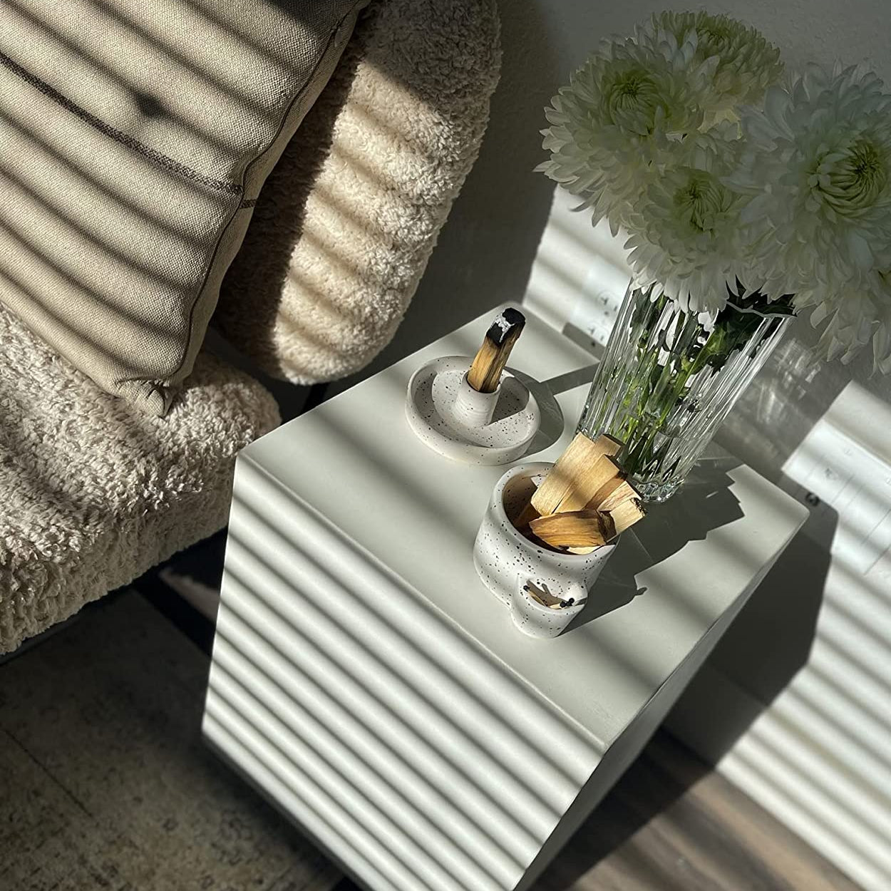 White side table with decorative items in a softly lit room