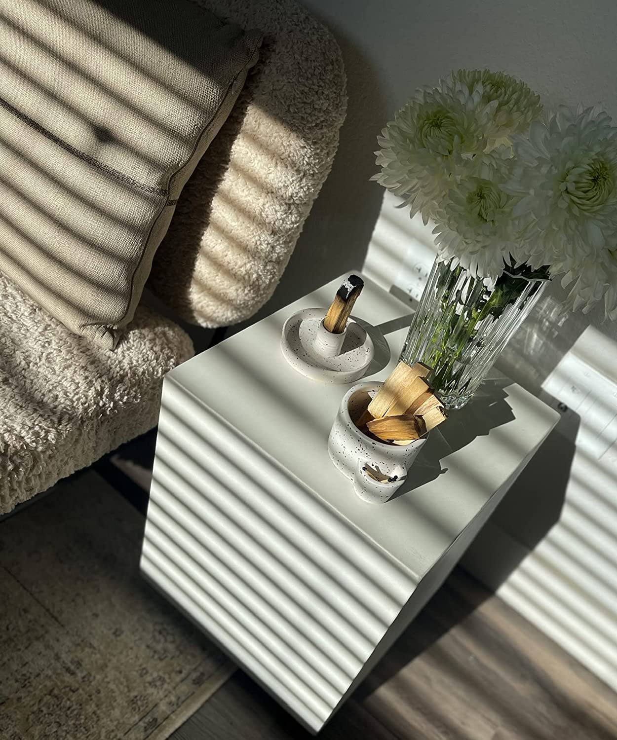 White side table with decorative items in a softly lit room