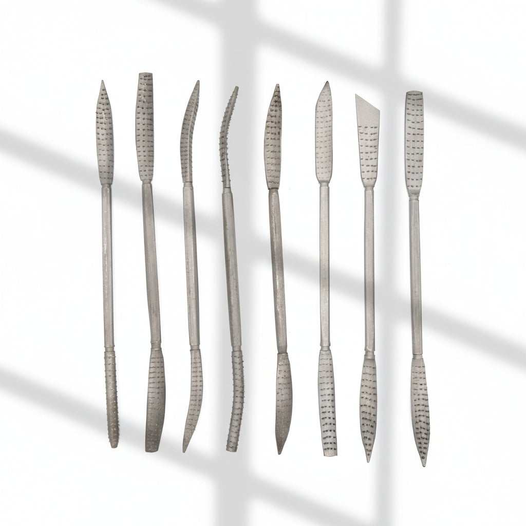 Set of metal sculpture rasps tools with textured handles on a white background