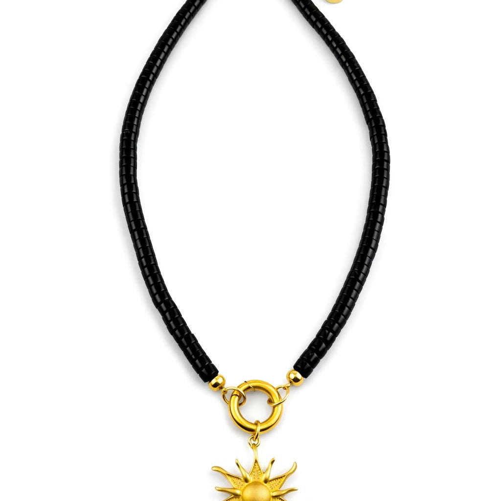 Moonrise Necklace - Onyx with a gold sun pendant on a white background