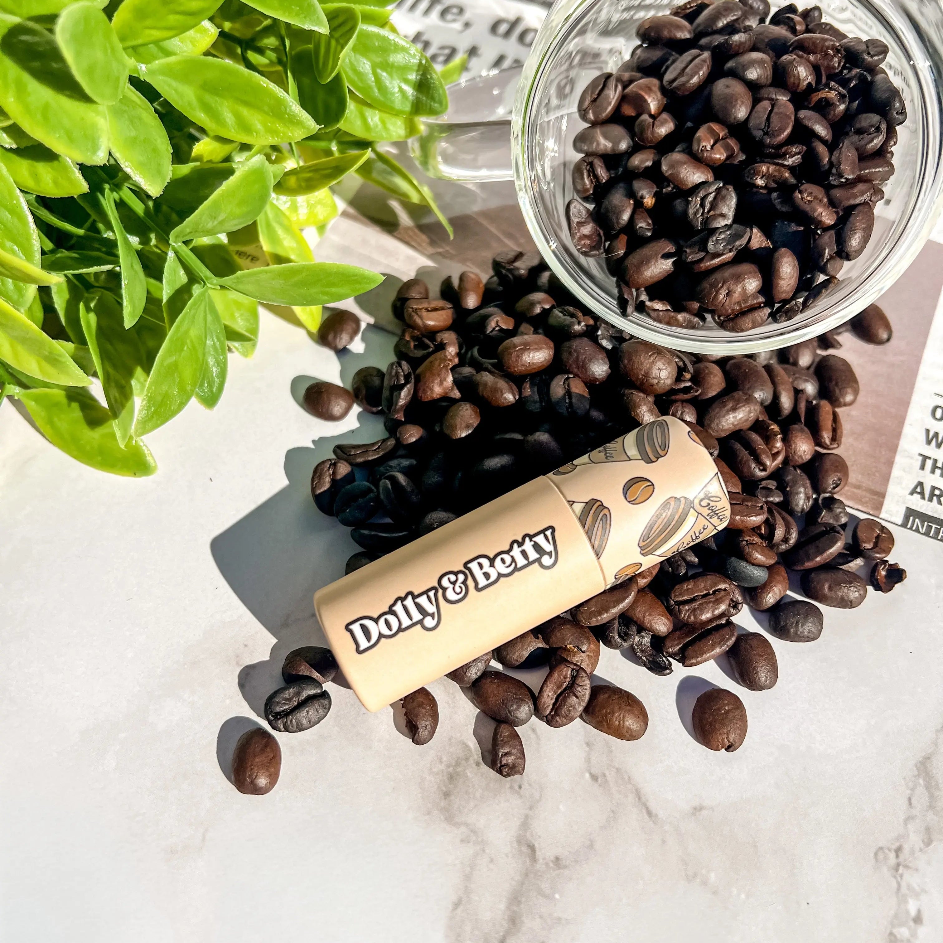 Dolly & Betty coffee beans with a container on a marble surface with a plant in the background