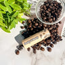 Dolly & Betty coffee beans with a container on a marble surface with a plant in the background