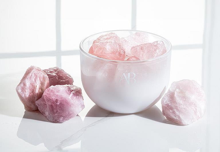 White bowl filled with pink stones on a white surface