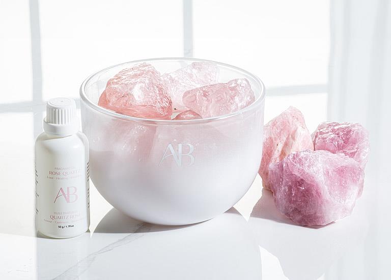 AB rose quartz crystal room fragrance with a bottle labeled 'AR' on a white surface.