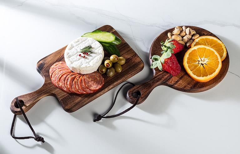 Two wooden cutting boards with assorted foods on a white background