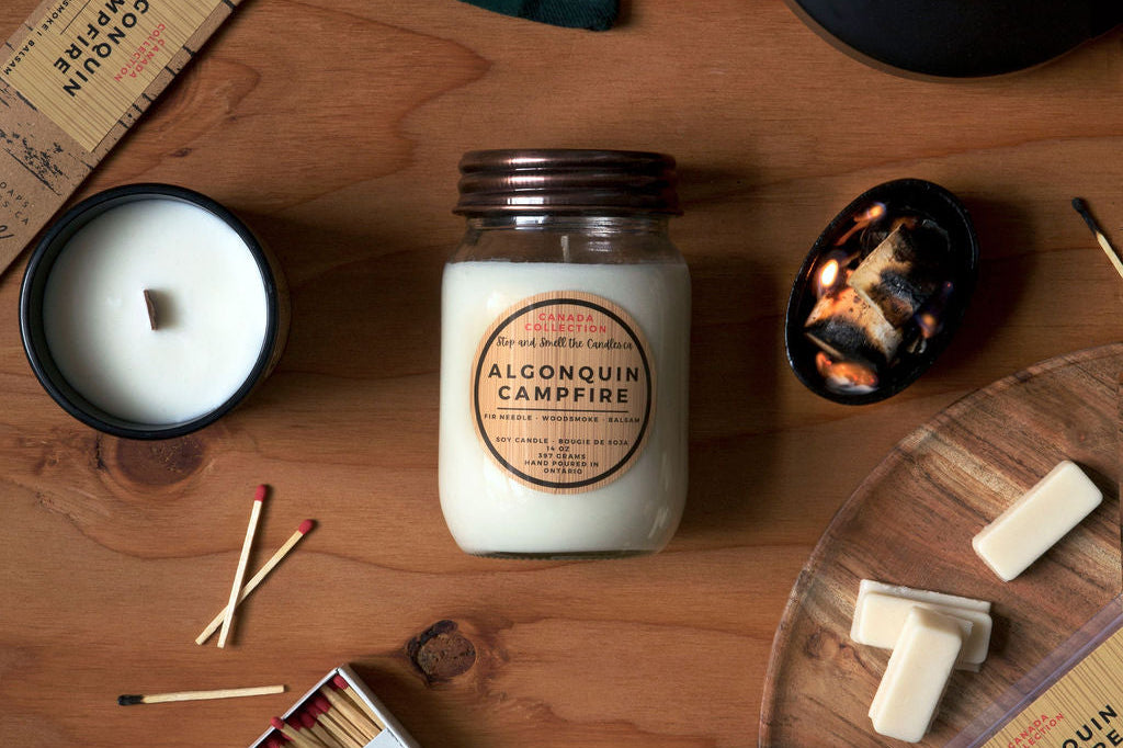 Collection of candles and matchbox on a wooden surface with 'Alconquin Campfire' branding.