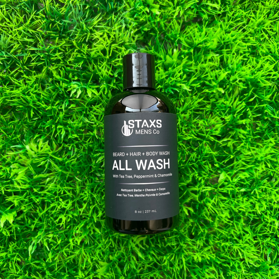 Bottle of Staxs Mens Co all wash on a grass background