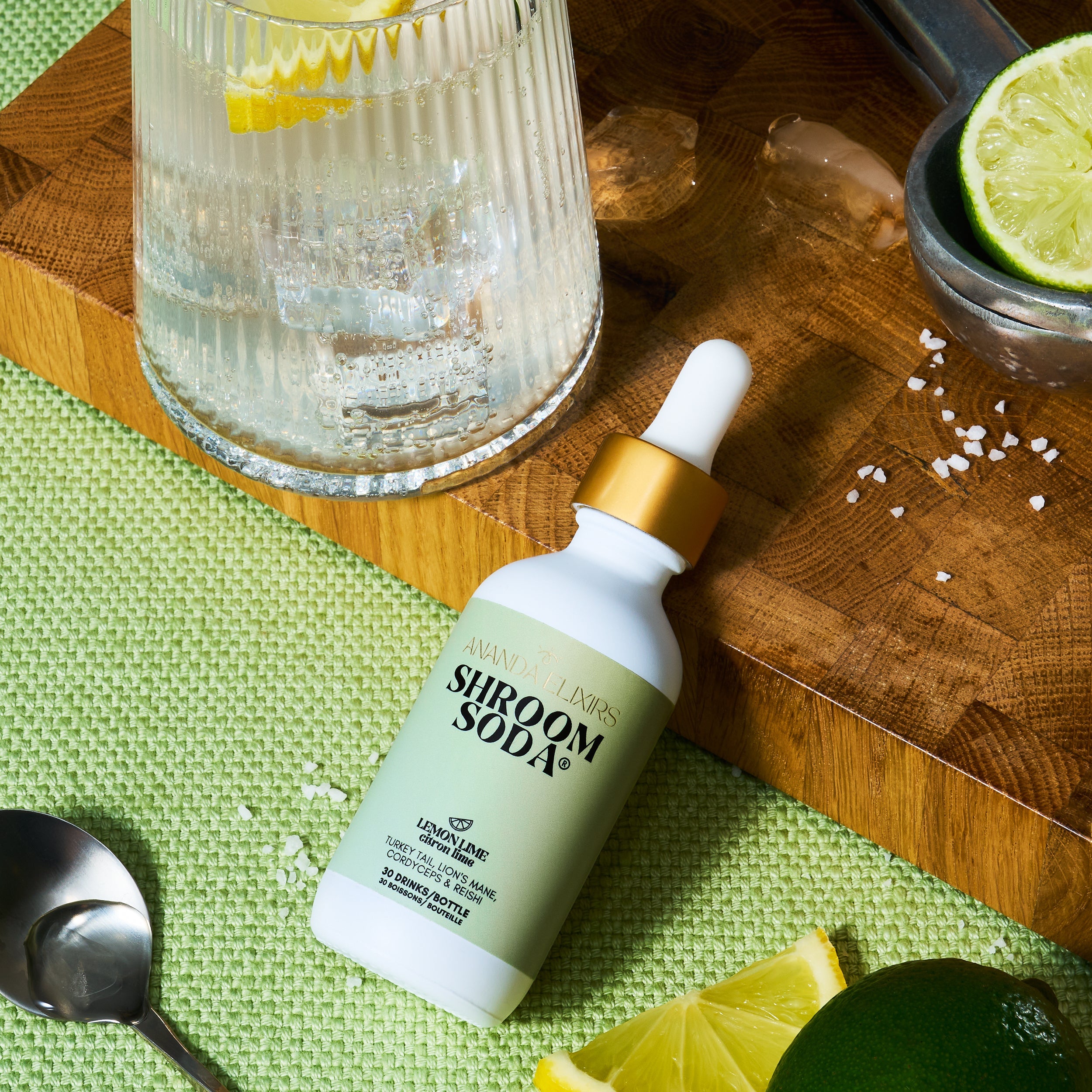 Shroom Soda bottle on a wooden cutting board with lemon and lime slices.