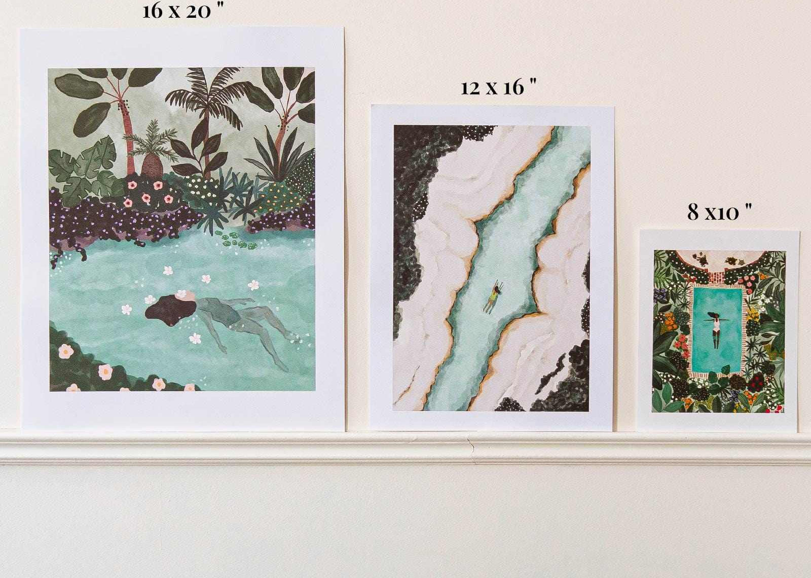 Three framed artworks of different sizes on a white wall.