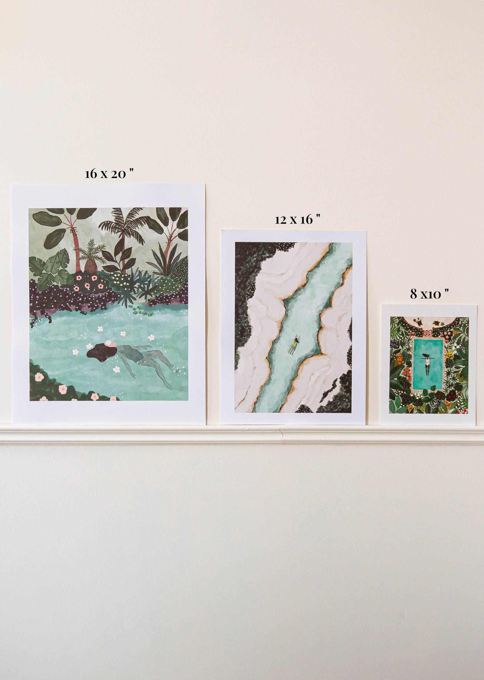 Three framed artworks of different sizes on a white wall.