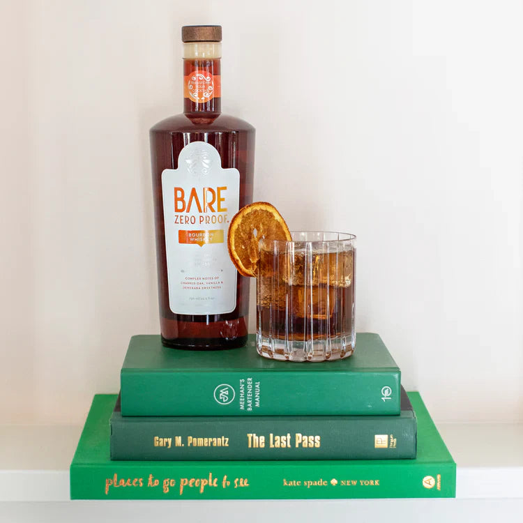 Bottle of Bare Zero Proof alcohol with a glass of cocktail on top of books  The Sobr Market