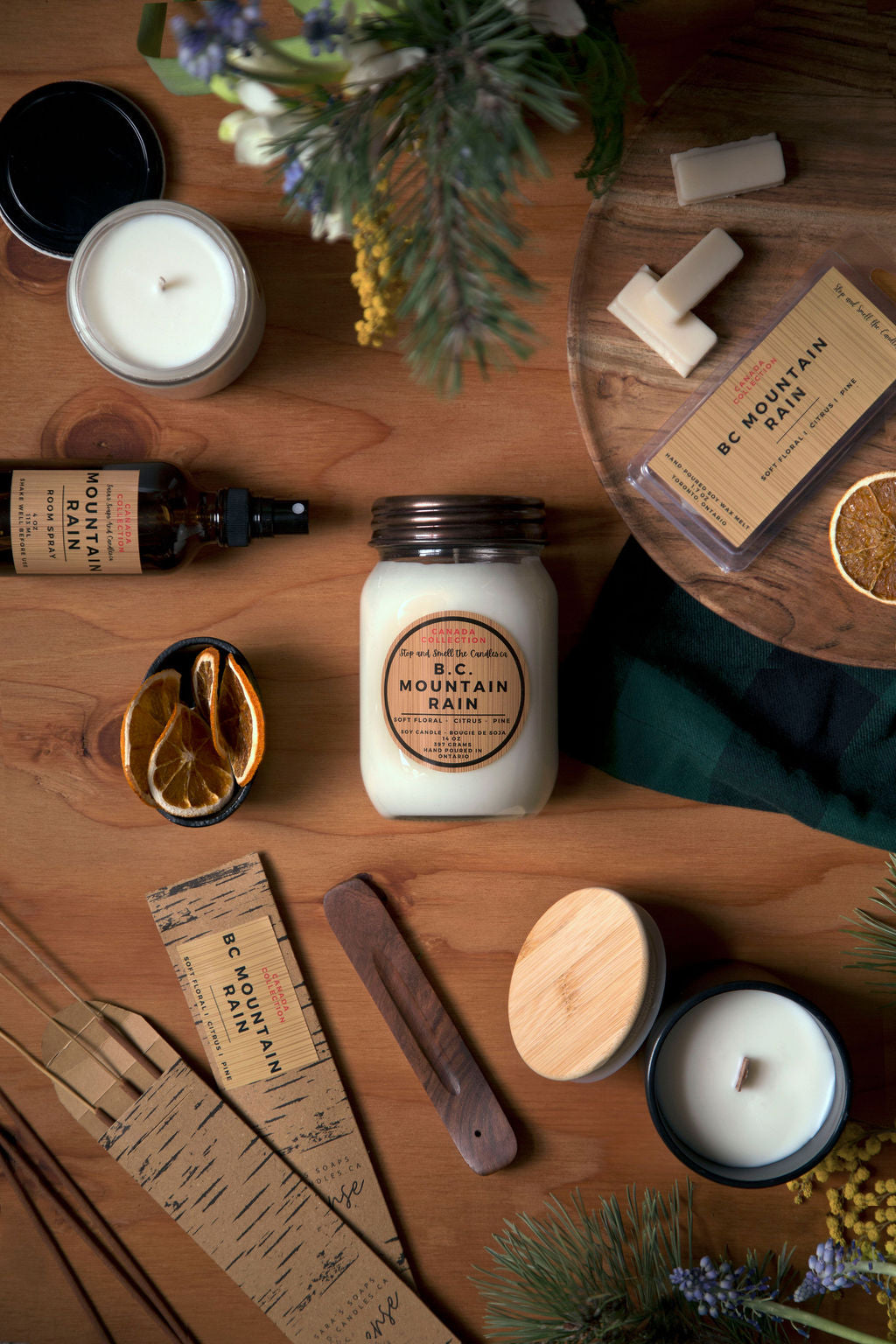 Collection of candles, soaps, and other products on a wooden surface with a natural theme.