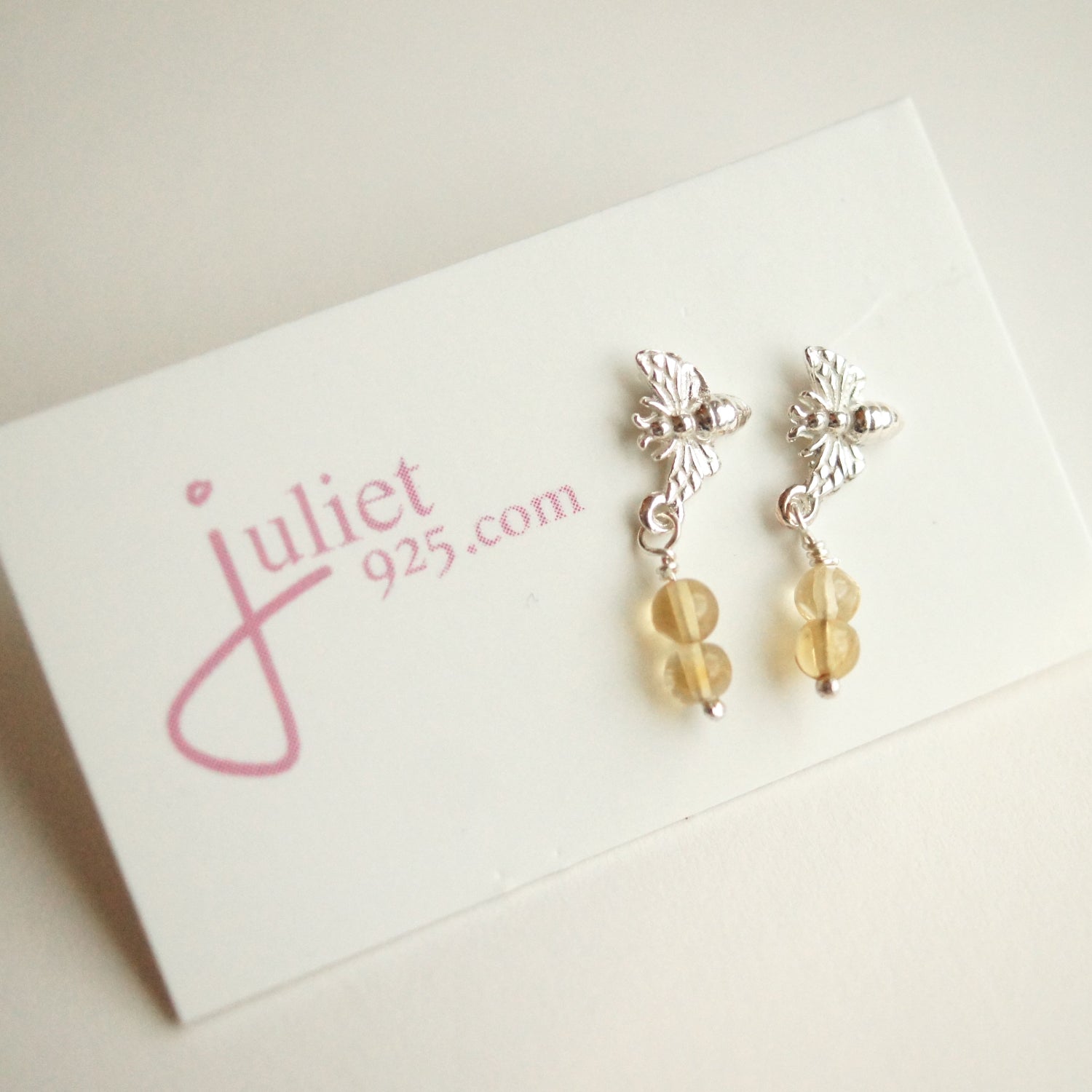 Silver earrings with yellow beads on a 'juliet 925.com' card.